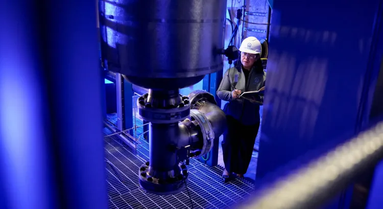 Aether engineer inspecting a section of the 100 gpd scale demo plant.